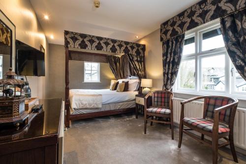 a bedroom with a bed and two chairs and a window at The Howbeck & The Retreat Central location, incl off-site Health Club and parking EV point available, GREAT DEALS ON in Windermere