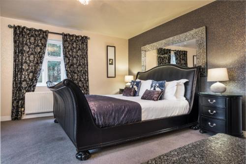 a bedroom with a large bed with a large mirror at The Howbeck & The Retreat Central location, incl off-site Health Club and parking EV point available, GREAT DEALS ON in Windermere