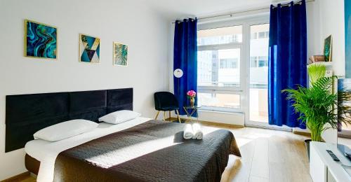 Un dormitorio con una cama y una ventana grande. en Charming Apartment in the City Center, en Varsovia