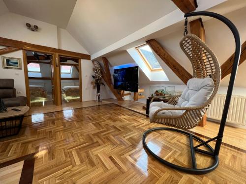 a living room with a wicker chair and a television at La Luna Rustic Deluxe Apartment with Free Jacuzzi, Bikes & Covered Parking in Našice