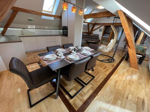 a kitchen and dining room with a table and chairs at La Luna Rustic Deluxe Apartment with Free Jacuzzi, Bikes & Covered Parking in Našice
