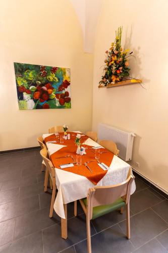 a dining room with a table and a painting on the wall at Gästehaus im Priesterseminar Salzburg in Salzburg
