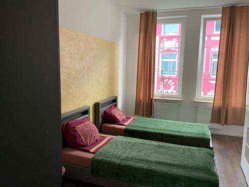 two beds in a room with two windows at Deluxe Wohnungen Dortmund Mitte in Dortmund