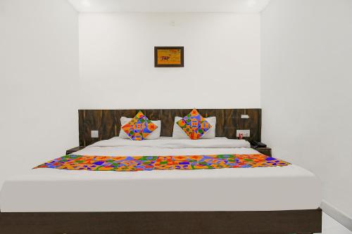 a bedroom with a large bed with a colorful comforter at FabHotel HTC in Bhopal