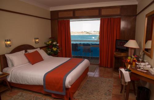 a hotel room with a bed and a view of the ocean at Lido Sharm Hotel Naama Bay in Sharm El Sheikh