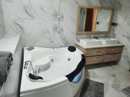 a white bathroom with a tub and a mirror at luxury cheerful 4 bedrooms villa in Calodyne in Calodyne
