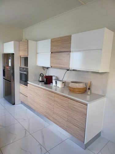 a kitchen with white cabinets and stainless steel appliances at luxury cheerful 4 bedrooms villa in Calodyne in Calodyne