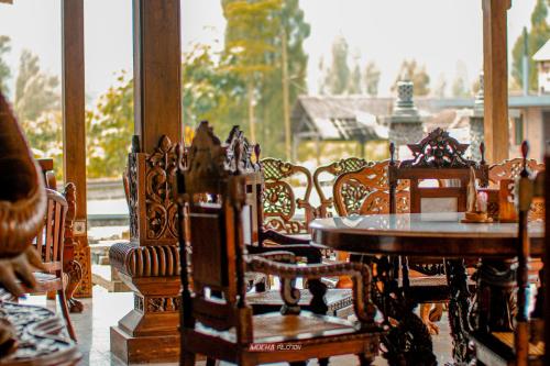 a group of wooden tables and chairs on a porch at Joglo Kecombrang Bromo in Ngadisari