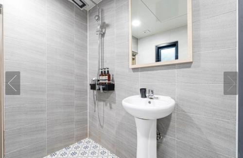 a bathroom with a white sink and a mirror at Tongyeong Mu in Tongyeong