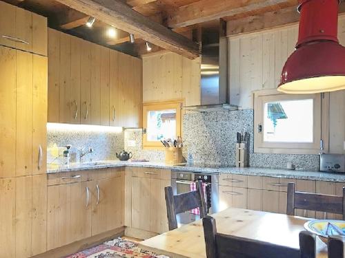 a kitchen with wooden cabinets and a wooden table at Happiness only! in Bruson