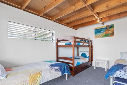 a bedroom with two bunk beds and a window at The Rise on Surfer- BEACHFRONT Pet Friendly WIFI in Middleton
