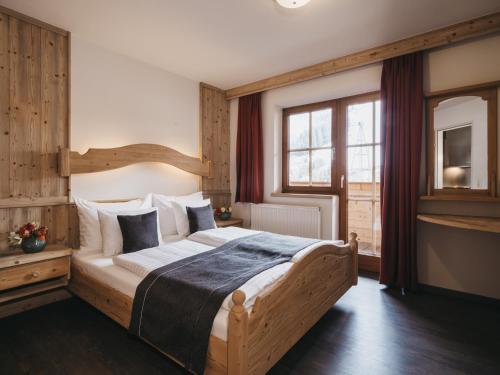 een slaapkamer met een groot houten bed in een kamer bij Residence Kristall by VAYA in Saalbach Hinterglemm