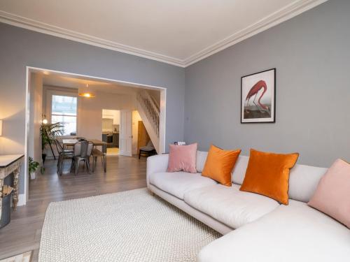 sala de estar con sofá blanco y almohadas de color naranja y rosa en Pass the Keys Lovely 2 bed home in Larkhall with street parking, en Bath