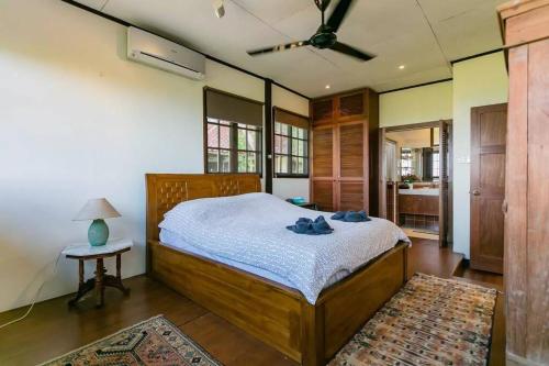 een slaapkamer met een bed en een tafel met een lamp bij Elysia Nongsa 70 Batam Luxury Villa in Nongsa