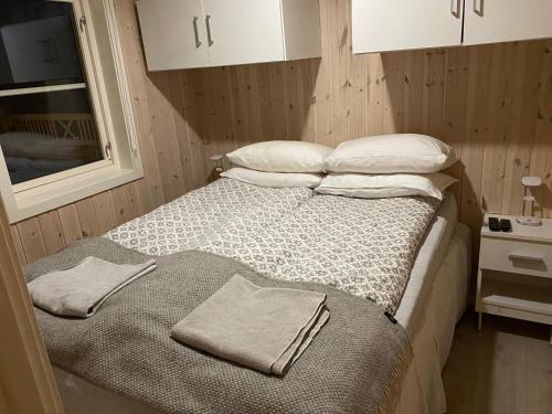 1 dormitorio con 1 cama con 2 toallas en Cabin Panorama Lofoten with Jacuzzi Magic view, en Offersøya