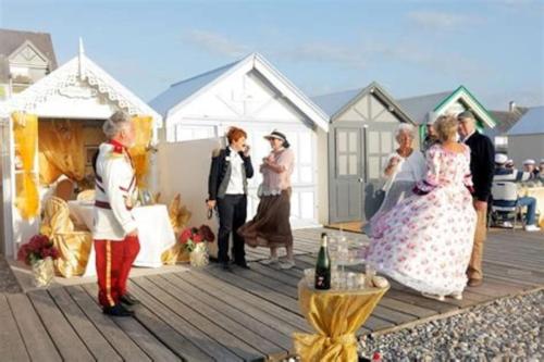 a group of people standing on a wooden deck at La Baigneuse maison avec jardinet et parking privé, à 200 m plage in Cayeux-sur-Mer