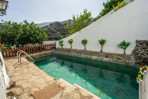 a swimming pool in the side of a house at Casa Rural El Majano in Moya