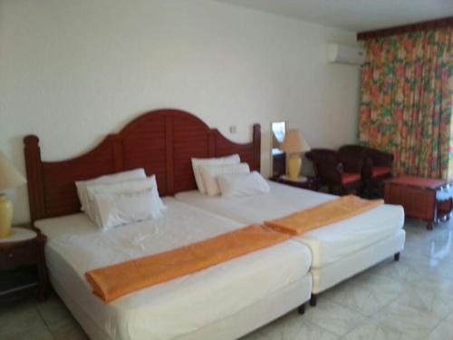 a bedroom with a large white bed with a wooden headboard at Just in paradise in Baie Nettle