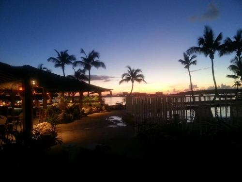 a sunset at a resort with palm trees in the background at Just in paradise in Baie Nettle