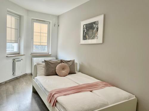 a small bedroom with a bed with a pink blanket on it at Nowoczesny Apartament z widokiem na rzekę i jezioro in Ełk