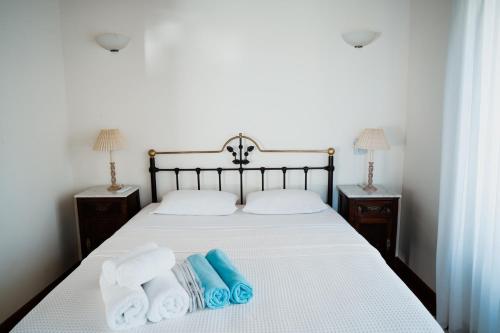 a bedroom with a bed with towels on it at Beautiful Traditional Stone House in the private Sea Front Olive Grove of Elaionas Nikou Luxury Villas in Alyfantá