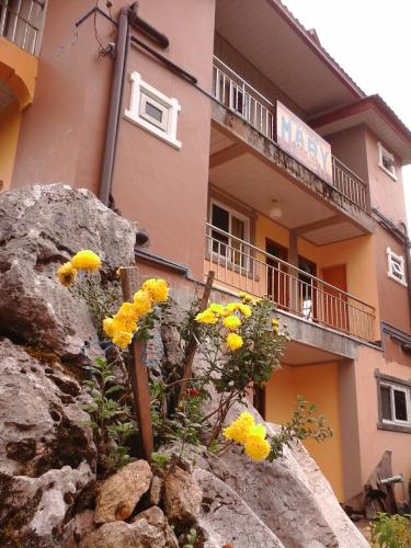 a building with yellow flowers on top of a rock at MOTHER MARRY INN in Sagada