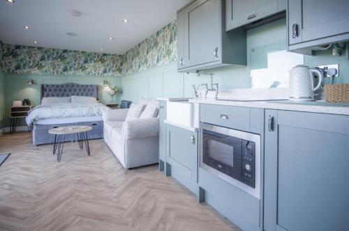 a kitchen and living room with a bed in a room at The Caswell Bay Hide Out - 1 Bed Cabin - Landimore in Gowerton