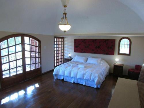 um quarto com uma cama grande num quarto em CASA VILLA LOS SAUCES em Luján de Cuyo