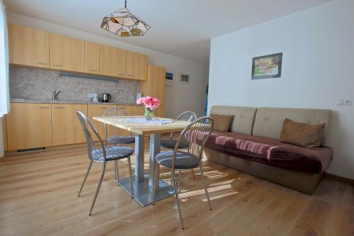 un tavolo e sedie in una cucina con divano di Residence die Färbe a Vipiteno