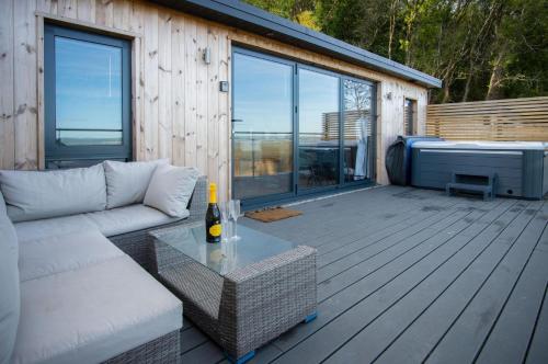 a living room with a couch and a table on a deck at The Rhossili Bay Secret - 1 Bed Cabin - Landimore in Gowerton