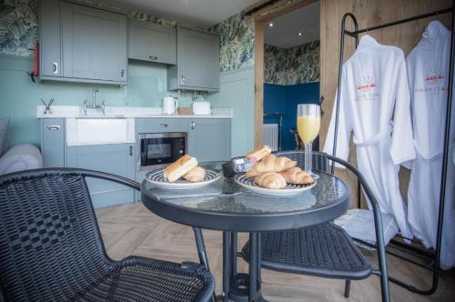 a table with plates of bread on it in a kitchen at The Rhossili Bay Secret - 1 Bed Cabin - Landimore in Gowerton