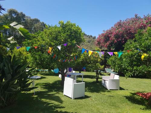 a garden with flags and tables and chairs in the grass at Arenosu Comfort Country Guesthouse in Fertilia