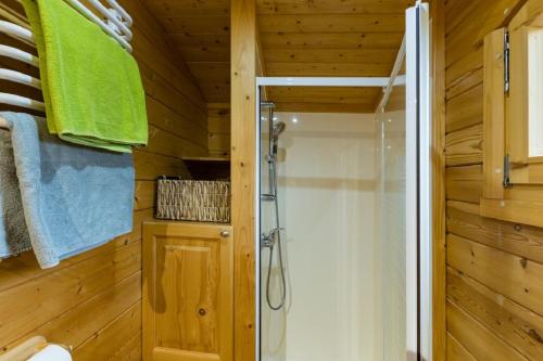 La salle de bains est pourvue d'une douche et de murs en bois. dans l'établissement Roulotte de la Villa Font Vive - Tout équipée, tout confort, situation idéale Sud Ardèche, à Grospierres