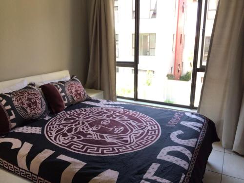 a bedroom with a bed and a window at Lovely, Modern, Contemporary 1 Bedroom Apartment. in Sandton