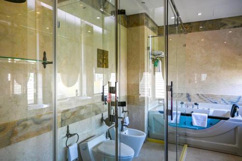 a bathroom with a shower and a toilet and a sink at Reef Boutique Hotel in Manama