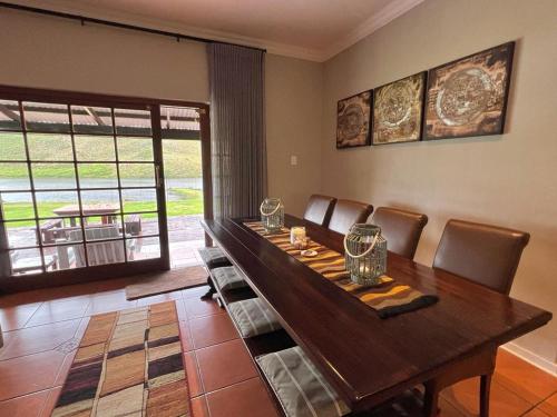 a dining room with a wooden table and chairs at Le Rendezvous in Dullstroom