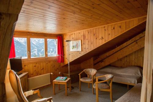 a room with a attic with a bed and chairs at Vichava 8, Süd in Ftan