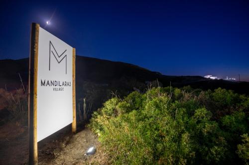 a sign in front of a mountain at night at Mandilaras Village in Vívlos