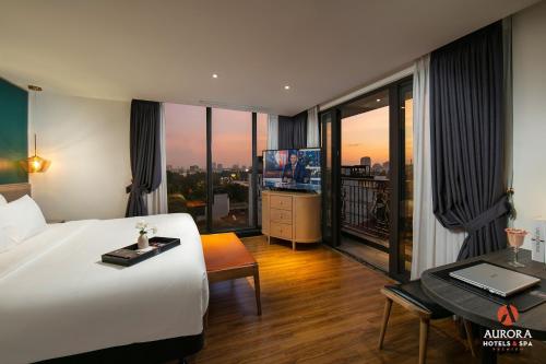 a hotel room with a bed and a desk with a laptop at Aurora Premium - A Lifestyle Hotel in Hanoi