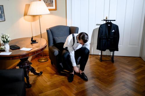 a man in a room looking down at his shoes at Hotel Hollerbusch in Weimar