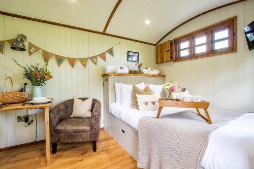 sypialnia z łóżkiem i krzesłem w pokoju w obiekcie Black Mountain bespoke breaks w mieście Brecon