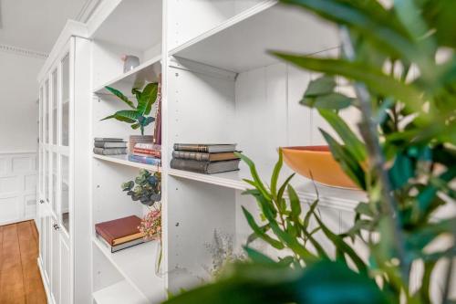 a book shelf with books and plants in a room at Beautiful 2 bed apartment in the heart of the city in Norwich
