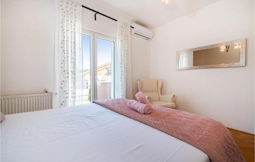 um quarto com uma cama com um cobertor rosa em 3 Bedroom Gorgeous Home In Zadar em Murvica