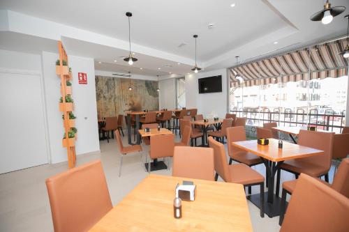 a restaurant with tables and chairs and a cafeteria at Hostal Gran Vía in Pinto