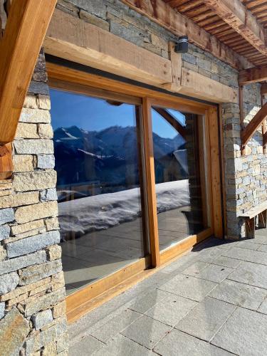 a window in a stone building with a view of mountains at Chalet Fontaines in LʼHuez