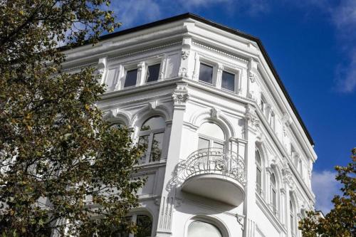 - un bâtiment blanc avec un balcon au-dessus dans l'établissement Sleephotels Casino, à Hambourg