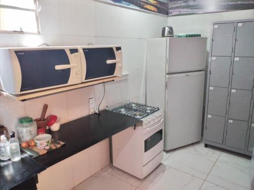 a small kitchen with a stove and a refrigerator at Angel Locação de Quartos in Brasilia