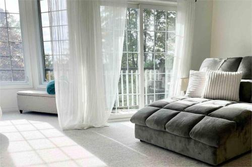 a living room with a couch and a large window at The Bruce Beach House - Cozy cottage by the lake! in Moraviantown