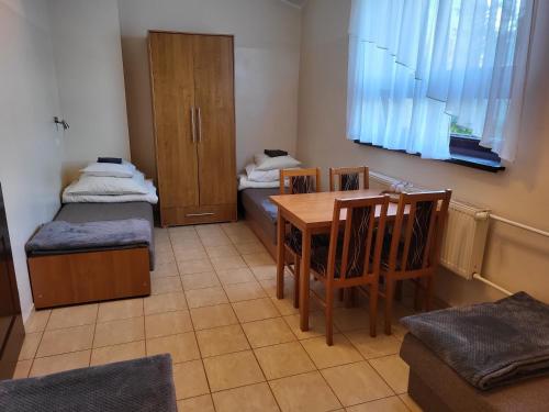 a room with a table and chairs and a room with two beds at Hotelik OSiR Lubawa in Lubawa