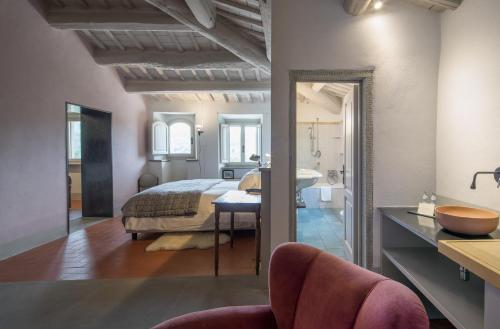 a bedroom with a bed and a bathroom with a sink at Casolese di Vignamaggio in Greve in Chianti